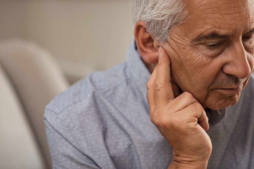 elderly man suffering from hearing loss